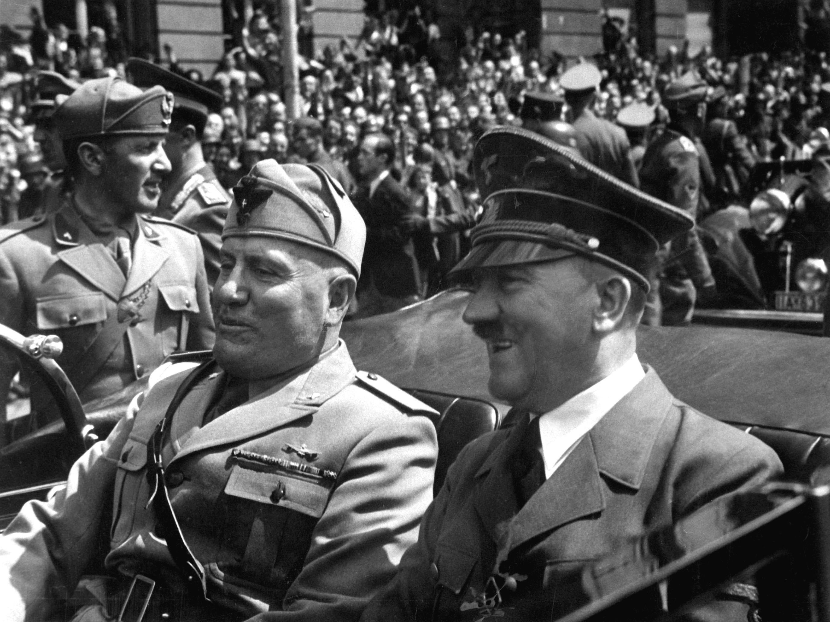 Benito Mussolini (left) and Adolf Hitler (right) riding through the streets of Munich, Germany, in 1940. Mussolini (Italy) and Hitler (Germany) formed an Axis in 1936.